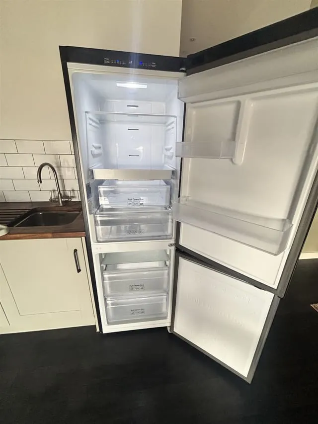 Empty, cleaned fridge-freezer with door open, Lewisham flat